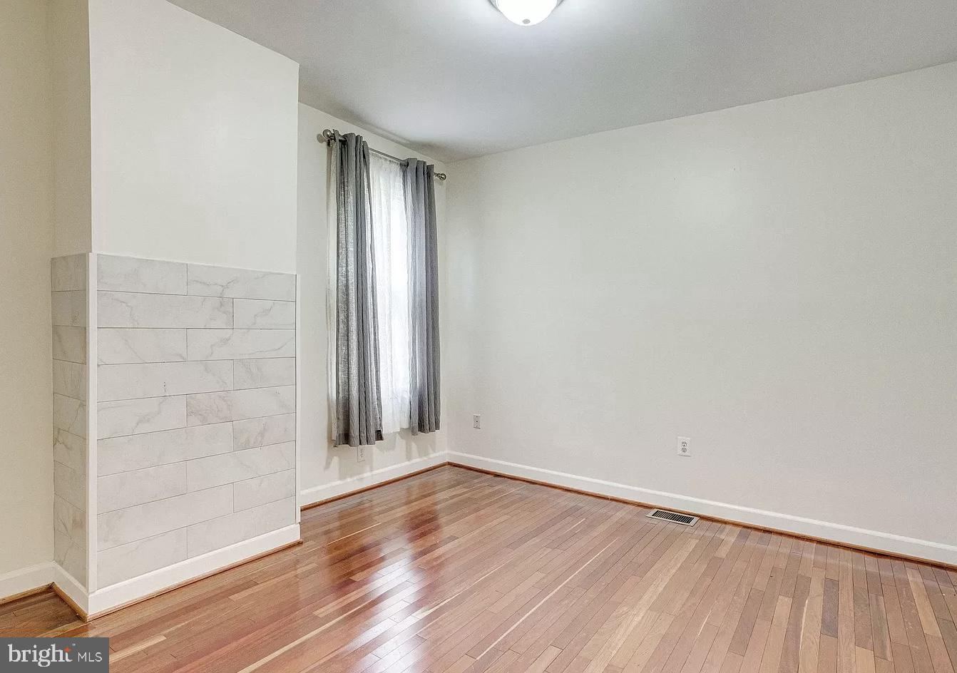 595 Columbia Road Northwest Washington, DC 20001 - Photo 18 of 36 an empty room with wooden floor and windows