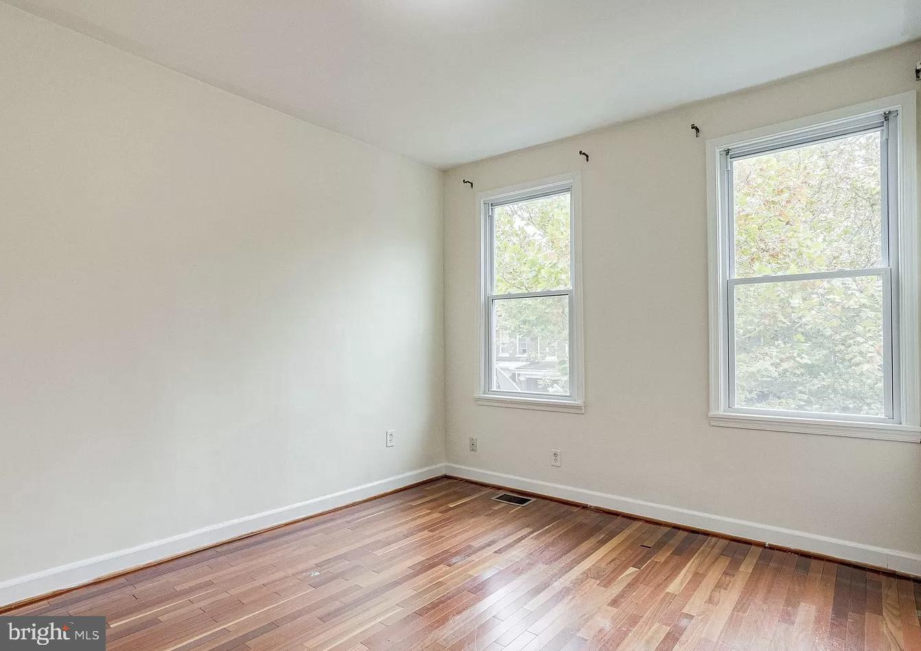 595 Columbia Road Northwest Washington, DC 20001 - Photo 21 of 36 a view of an empty room with wooden floor and a window