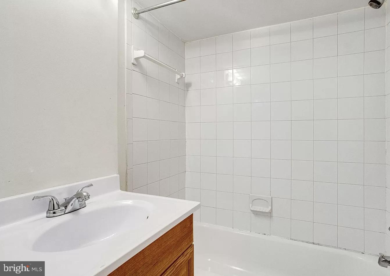 595 Columbia Road Northwest Washington, DC 20001 - Photo 25 of 36 a bathroom with a bathtub a sink and a shower