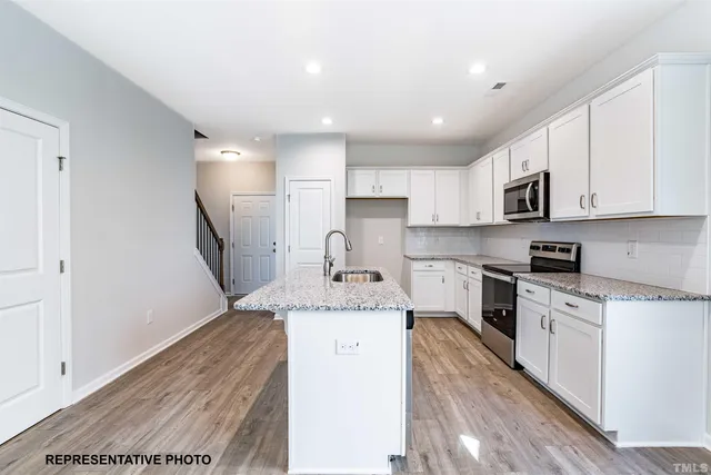 a kitchen with a sink a stove a refrigerator and cabinets
