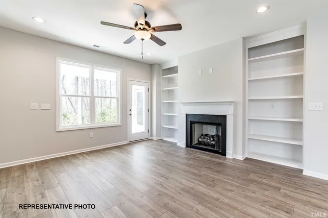 a view of an empty room with a fireplace and a window