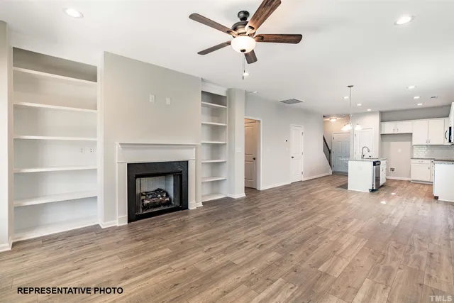 a view of an empty room with a fireplace and a window