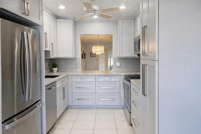 5140 Poppy Place, Unit B Delray Beach, FL 33484 - Photo 2 of 14 a kitchen with a refrigerator sink and cabinets