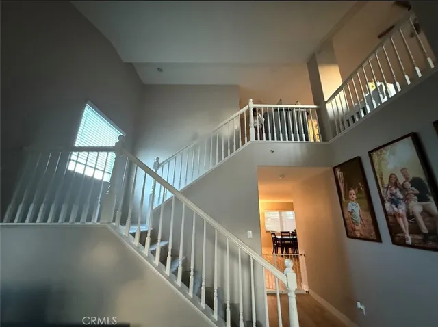 a view of staircase with railing and a chandelier