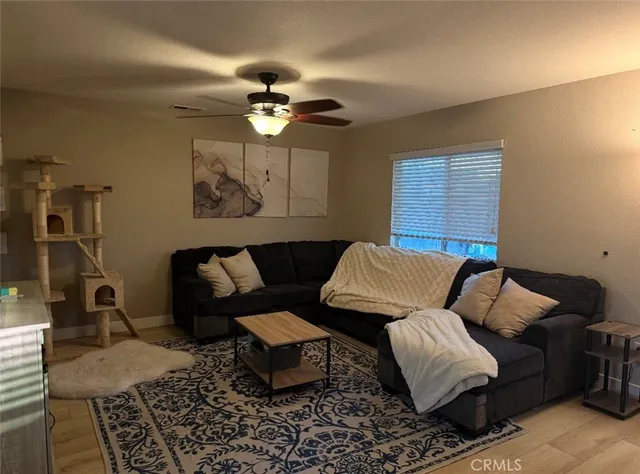 a living room with furniture a ceiling fan and a rug