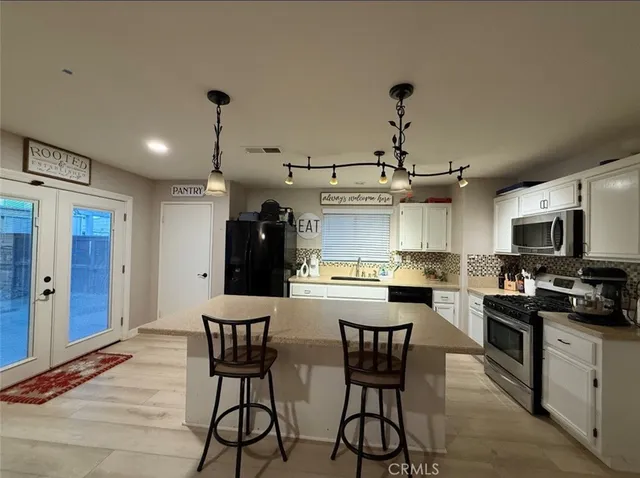 a kitchen with stainless steel appliances kitchen island granite countertop a sink and cabinets
