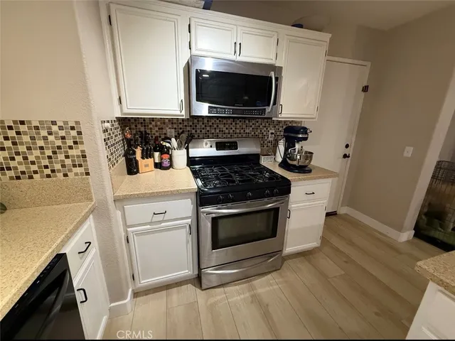 a kitchen with granite countertop a stove and a microwave