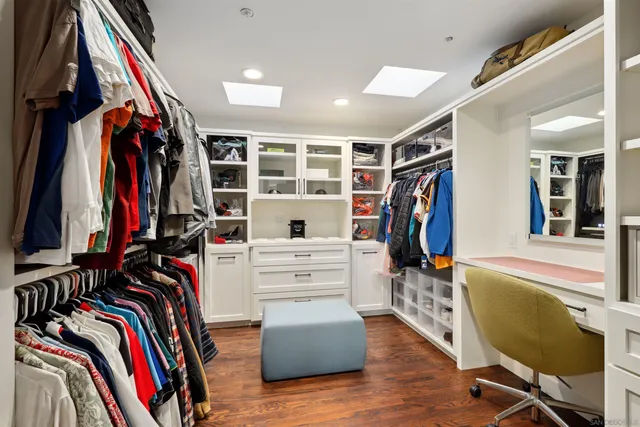 a view of walk in closet with clothes and shoes