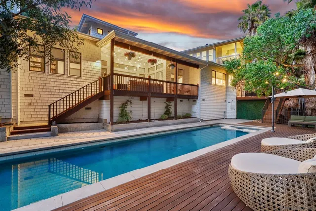 a view of house with swimming pool and outdoor seating