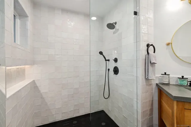 a bathroom with a granite countertop shower sink and mirror