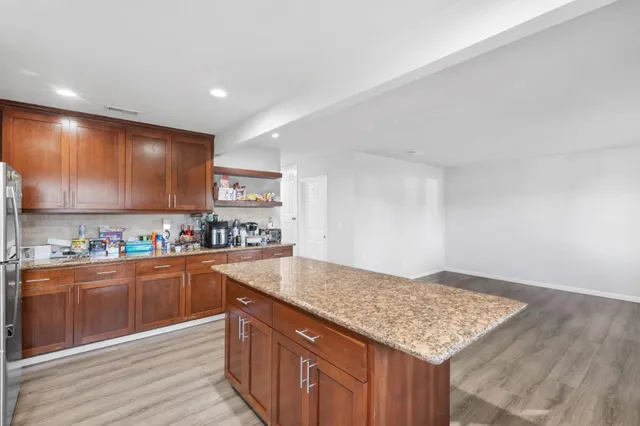 a kitchen with stainless steel appliances granite countertop a lot of counter space and wooden floor