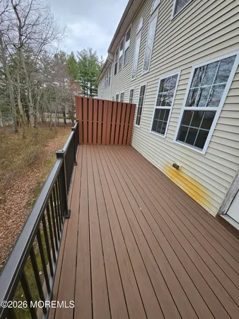 a balcony with wooden floor and fence and a bench