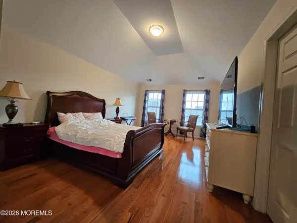 a bedroom with a bed and wooden floor