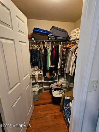 a view of walk in closet with clothes and shoes