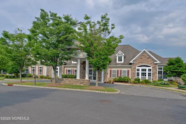 a front view of a house with a garden and trees