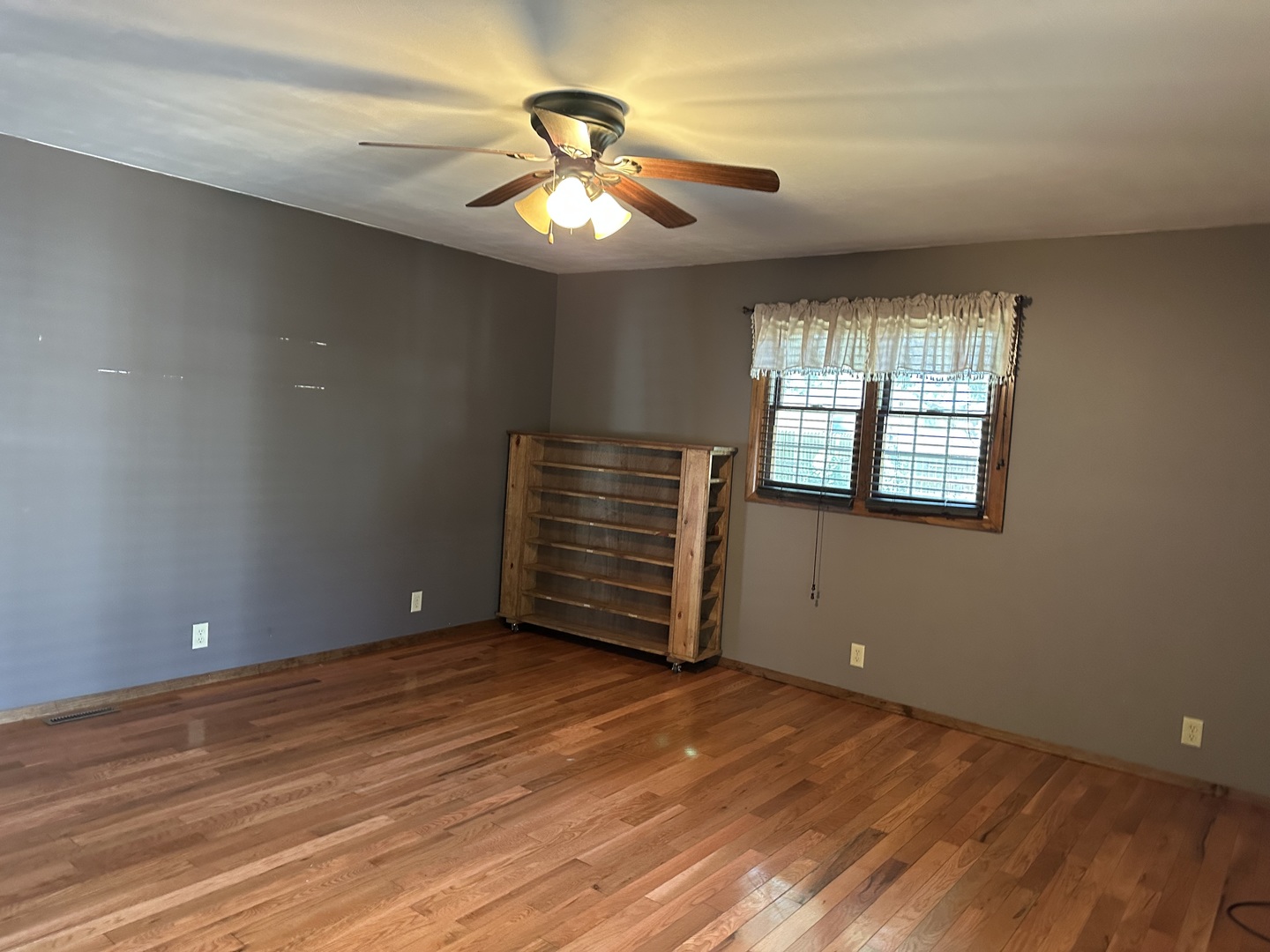 12855 Lawrence Road Sterling, IL 61081 - Photo 14 of 40 an empty room with wooden floor chandelier fan and windows