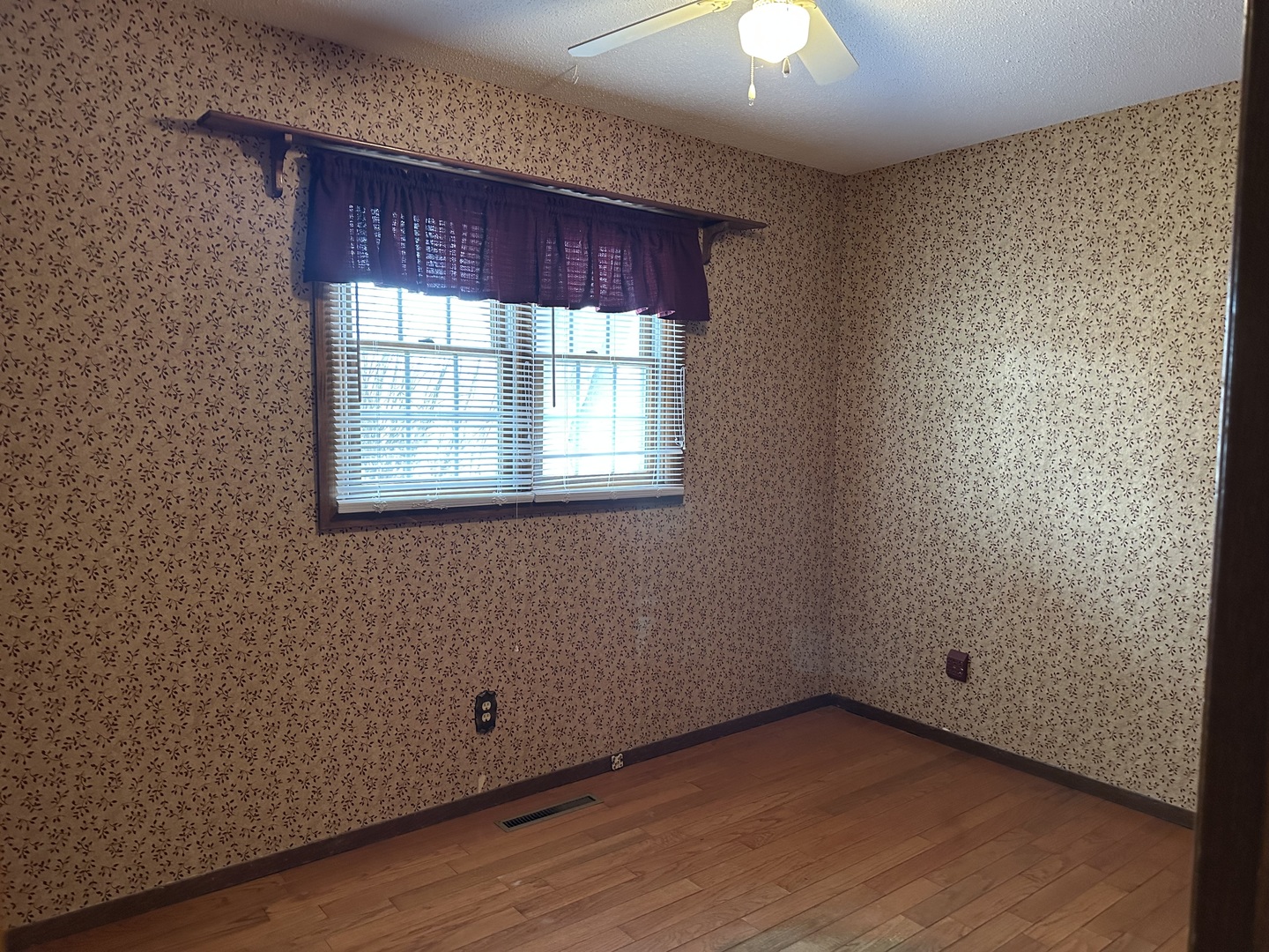 12855 Lawrence Road Sterling, IL 61081 - Photo 16 of 30 a view of an empty room with wooden floor and a window