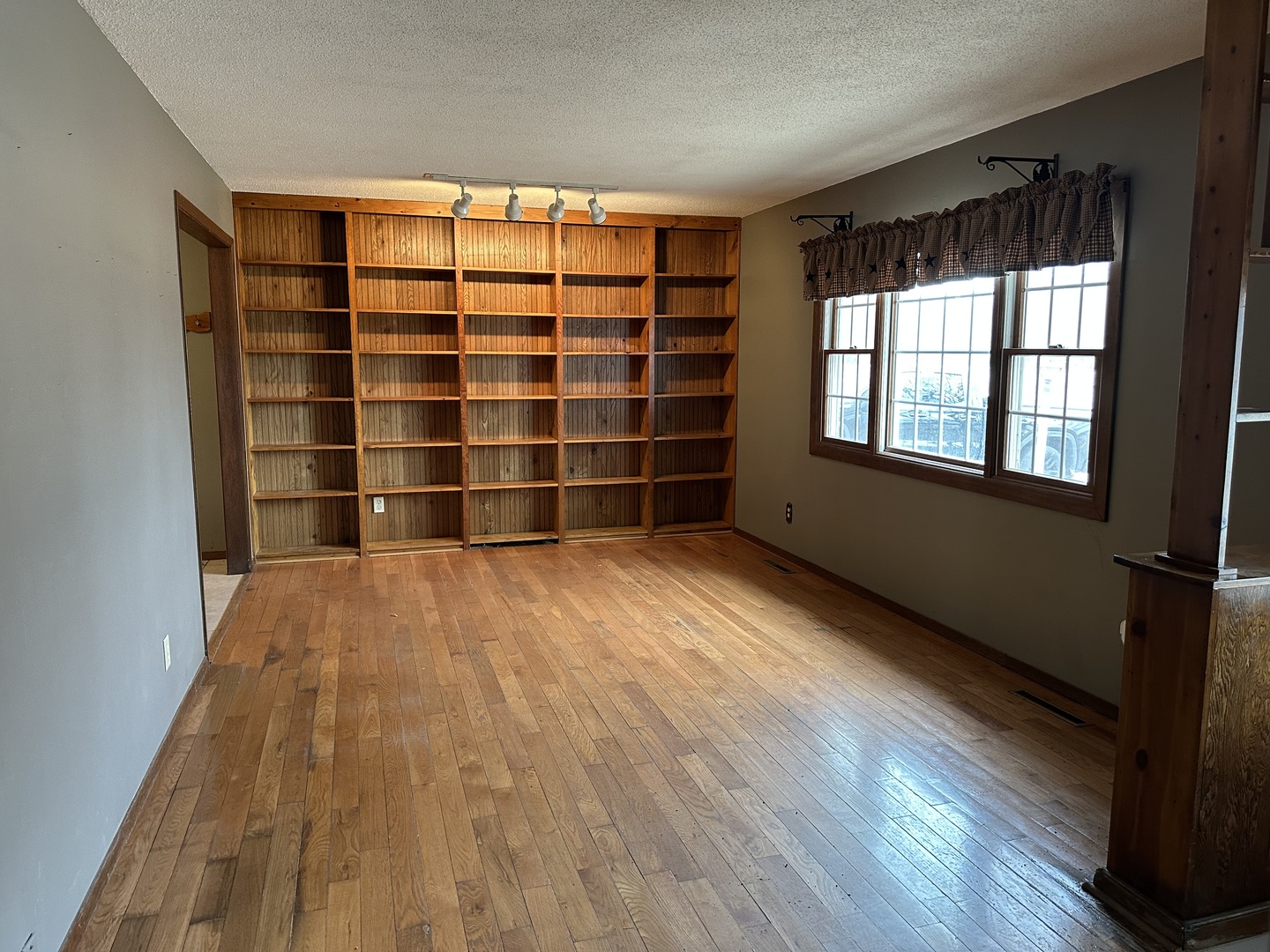12855 Lawrence Road Sterling, IL 61081 - Photo 4 of 30 a view of an empty room with a window and wooden floor