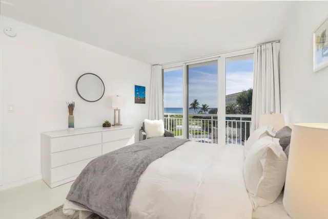 a bed room with a bed mirror and a large window