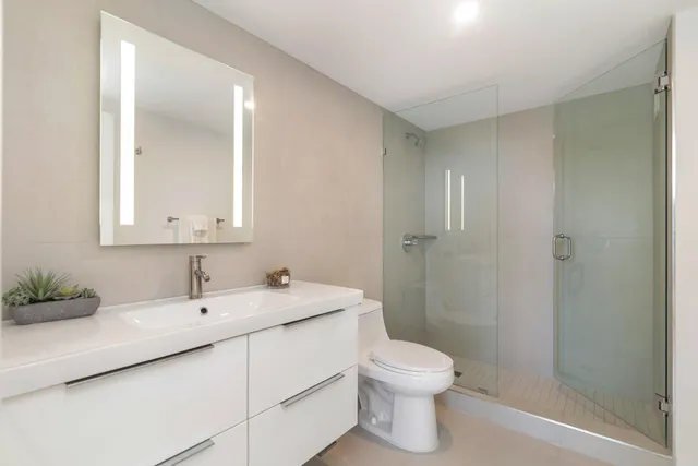 a bathroom with a sink a toilet and shower