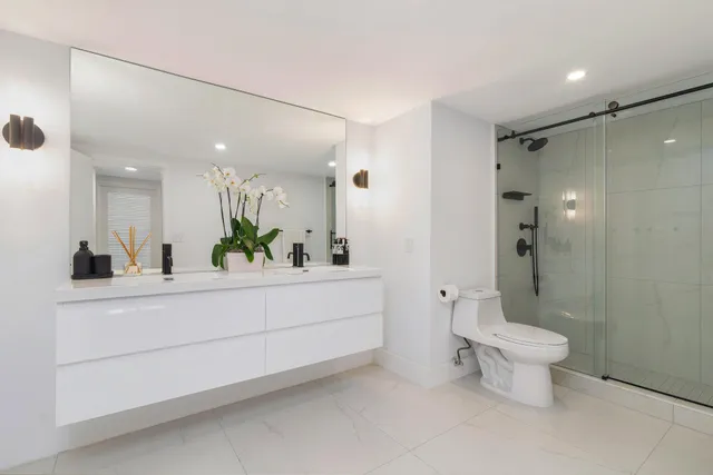 a bathroom with a double vanity sink toilet and a mirror
