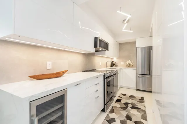 a kitchen with stainless steel appliances a stove a sink and a refrigerator