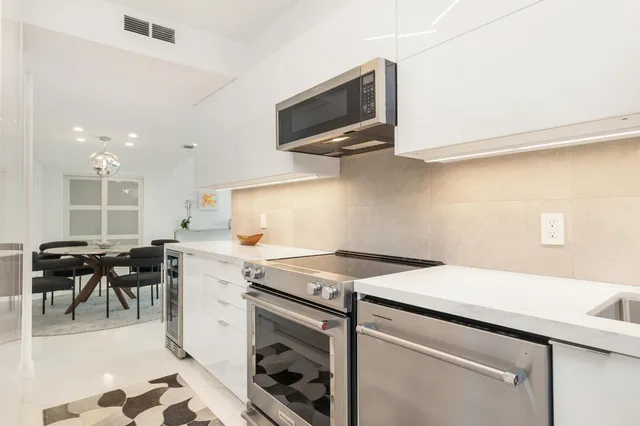 a kitchen with a sink a stove and chairs