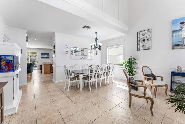 a dining room with furniture a chandelier and window