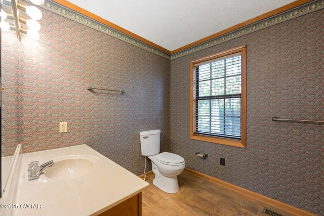 a bathroom with a sink toilet and window