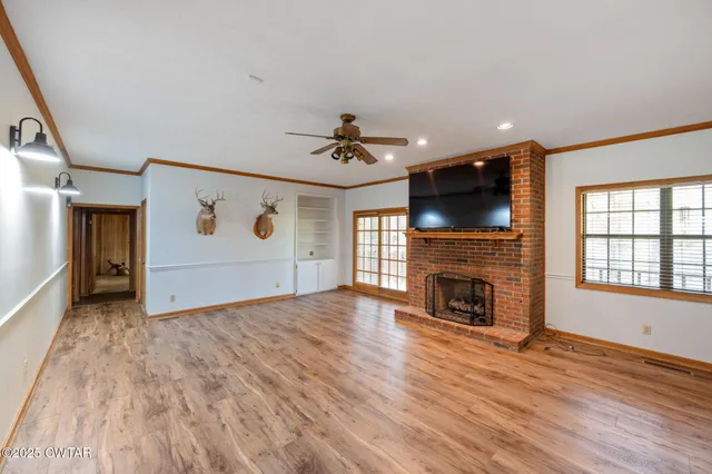 a view of an empty room with a fireplace and a window