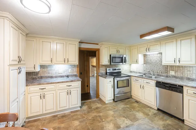 a kitchen with stainless steel appliances granite countertop a stove sink and cabinets