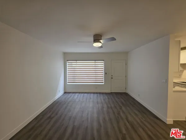 an empty room with a hardwood and ceiling fan