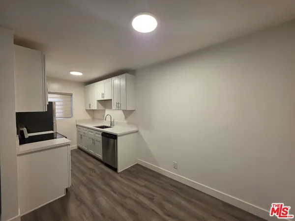 a kitchen with sink a microwave and cabinets