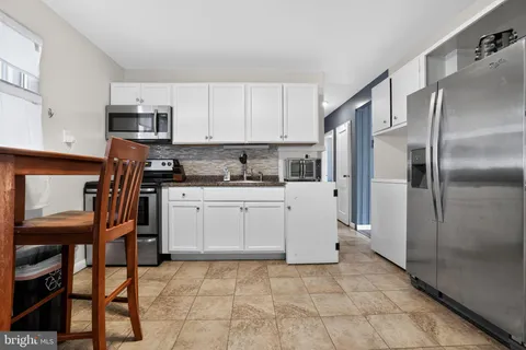a kitchen with stainless steel appliances a refrigerator sink and cabinets
