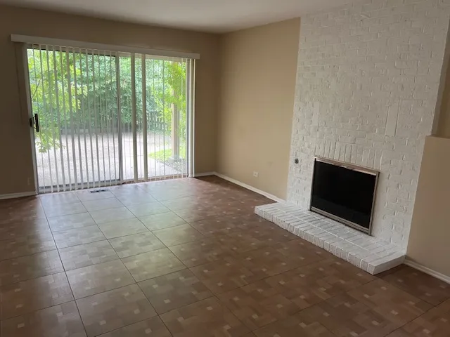 a view of an empty room with a fireplace and a window