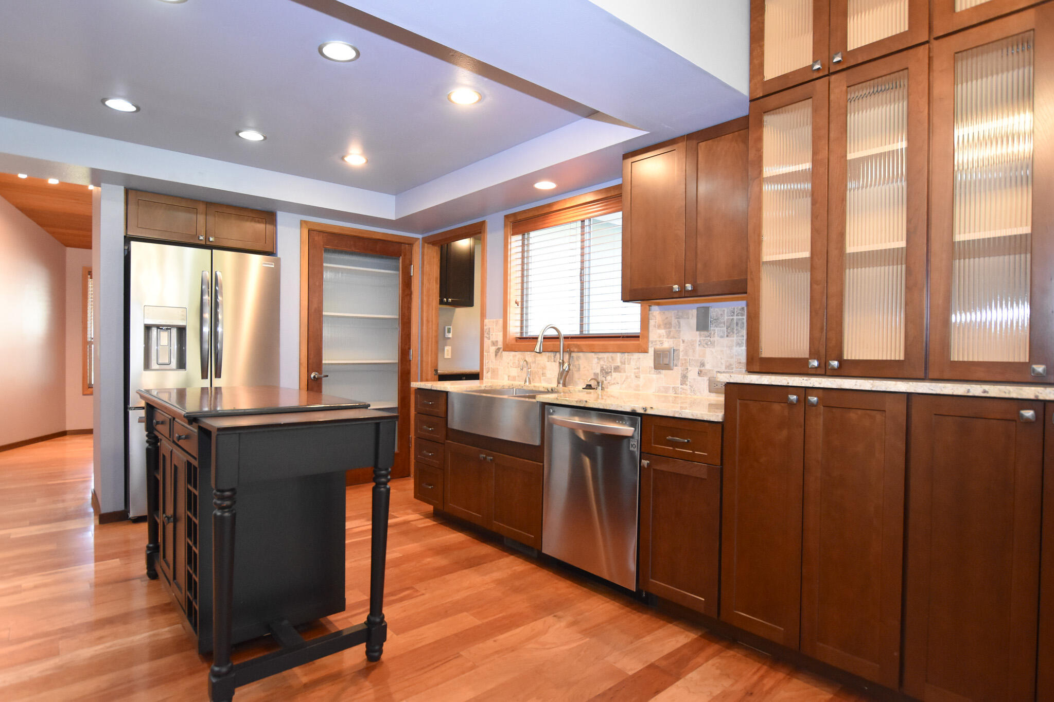 64730 Sylvan Loop Bend, OR 97701 - Photo 21 of 46 a large kitchen with kitchen island granite countertop a large window and wooden cabinets