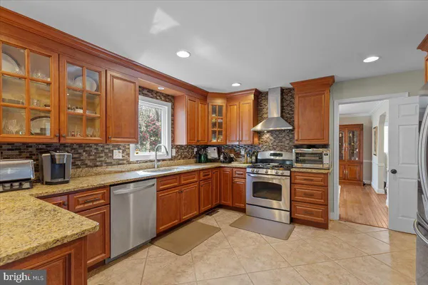 a kitchen with stainless steel appliances granite countertop a refrigerator and a stove top oven