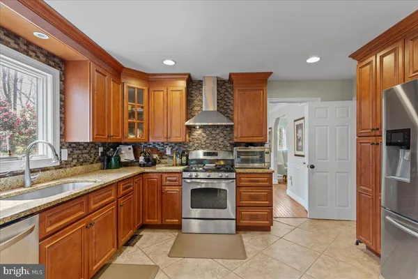 a view of a dining room and livingroom with furniture wooden floor a rug a chandelier and a mirror
