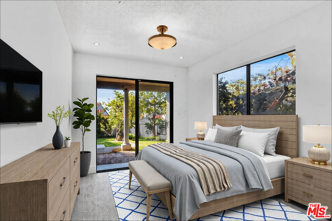 20948 Waveview Drive Topanga, CA 90290 - Photo 11 of 19 a bedroom with a large bed and a flat tv screen on dresser