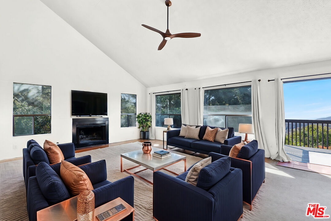 20948 Waveview Drive Topanga, CA 90290 - Photo 3 of 19 a living room with furniture a flat screen tv and a large window