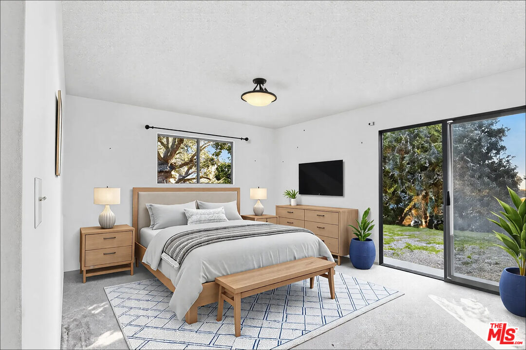 20948 Waveview Drive Topanga, CA 90290 - Photo 9 of 19 a bedroom with a bed and a flat tv screen