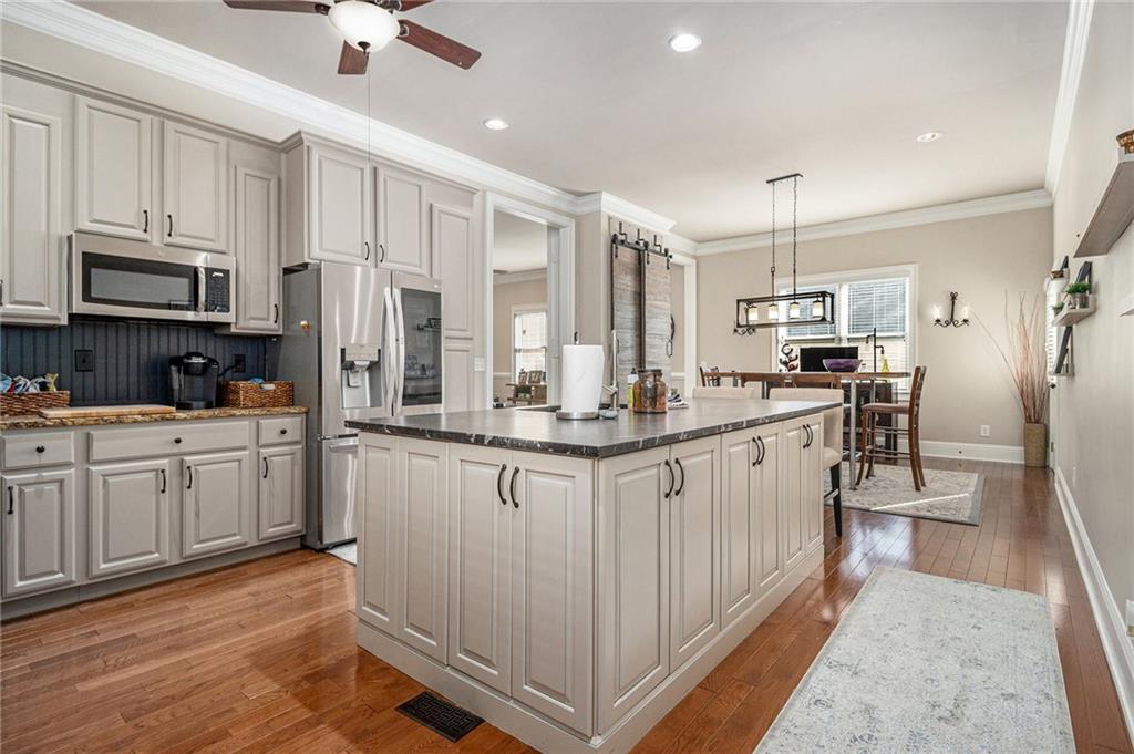 3433 Pierce Street Atlanta, GA 30337 - Photo 11 of 42 a kitchen with stainless steel appliances granite countertop a refrigerator a oven a sink dishwasher and white cabinets with wooden floor