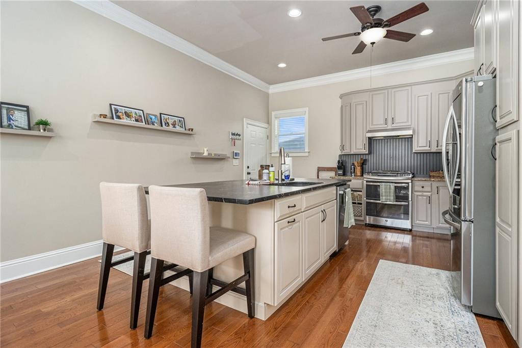 3433 Pierce Street Atlanta, GA 30337 - Photo 8 of 42 a kitchen with stainless steel appliances granite countertop a stove a sink dishwasher a refrigerator and white cabinets with wooden floor