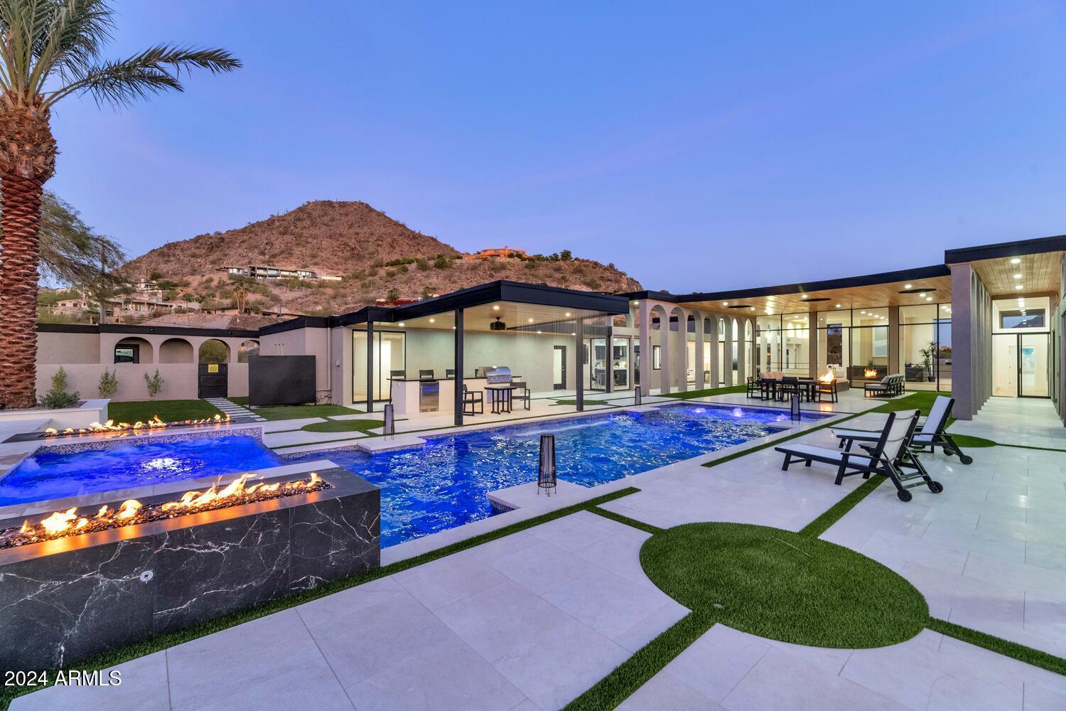 6664 North 40th Street Paradise Valley, AZ 85253 - Photo 27 of 36 a view of swimming pool with lawn chairs under an umbrella