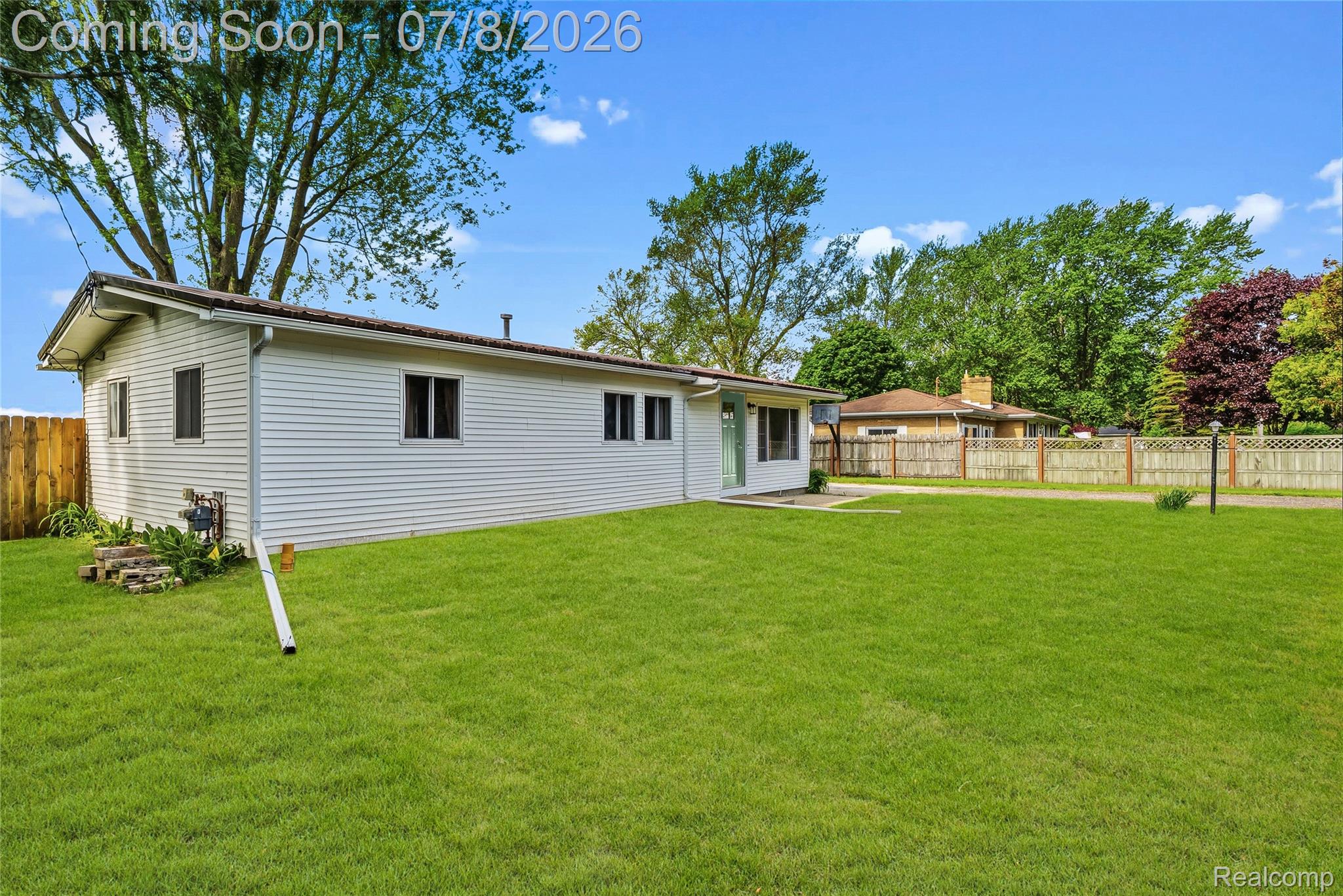 5698 McGrandy Road Bridgeport, MI 48722 - Photo 4 of 26 Expansive green lawn surrounds the white-sided residence with multiple window installations