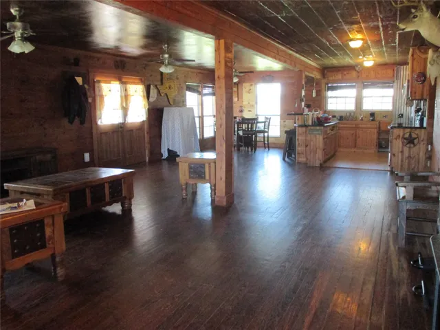 a view of a living room with kitchen view and wooden floor