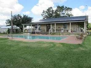 a front view of house with yard barbeque and outdoor seating