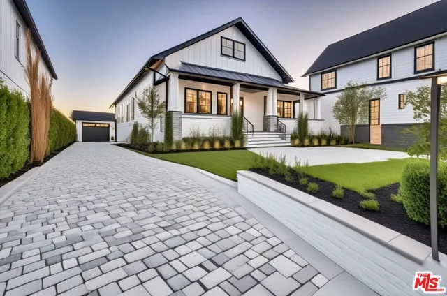 a front view of a house with a yard and potted plants