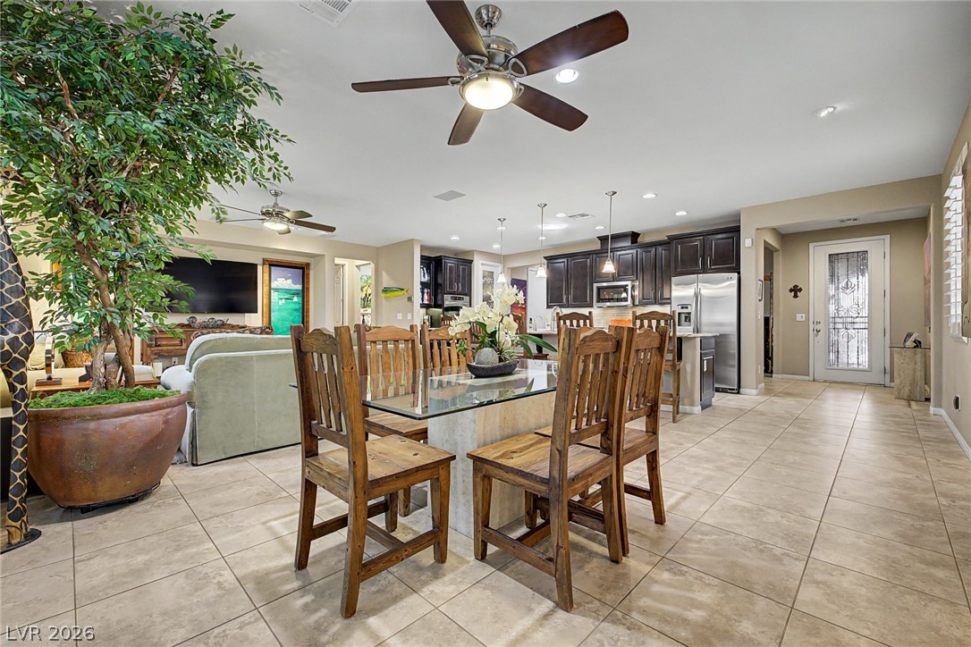 7415 Campbell Ranch Avenue Las Vegas, NV 89179 - Photo 21 of 52 An open-concept living space integrates dining, kitchen, and living areas with cohesive tiled flooring throughout.