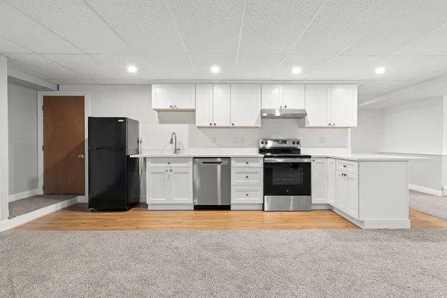 a kitchen with refrigerator and cabinets